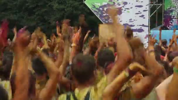 Crowd covered in paint jumping at festival — Stock Video