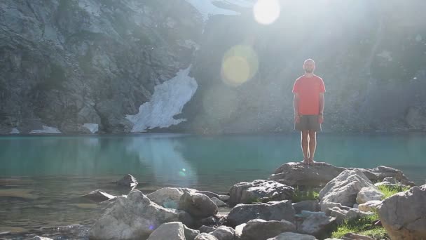 Hombre inclinándose en la orilla del lago — Vídeos de Stock