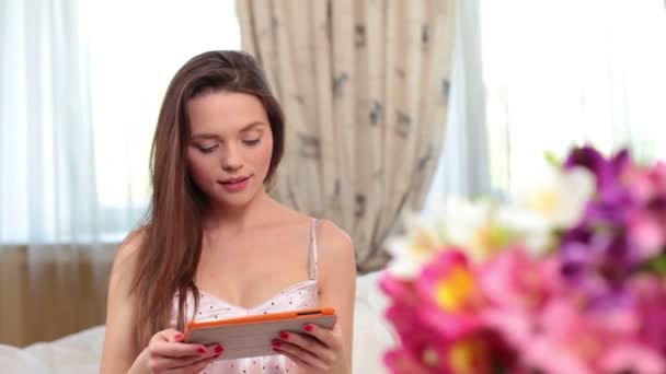 Женщина с помощью планшета в спальне — стоковое видео