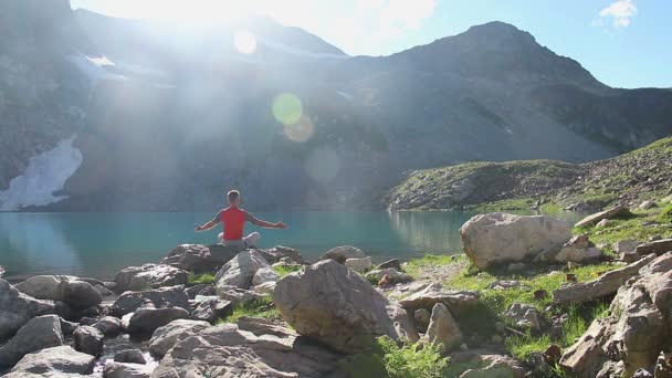 Турист занимается йогой у горного озера — стоковое видео