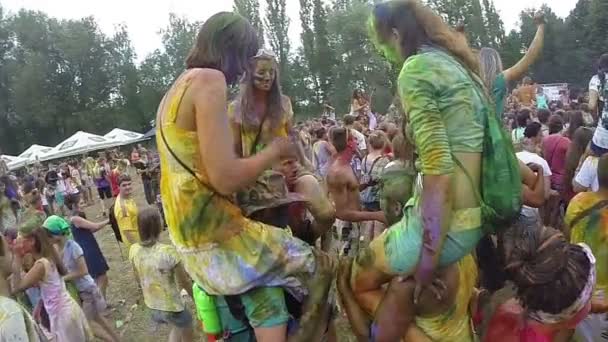 Girls sitting on boyfriends' shoulders at festival — Stock Video