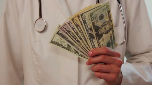 Dólares estadounidenses en manos del médico — Vídeo de stock