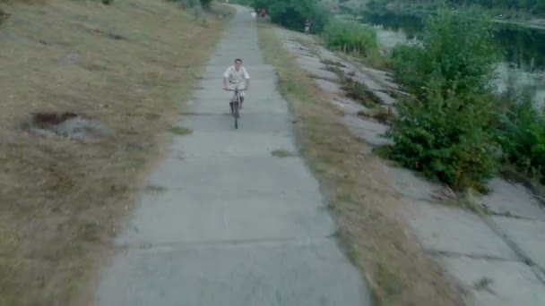 Человек на велосипеде по парковой аллее — стоковое видео