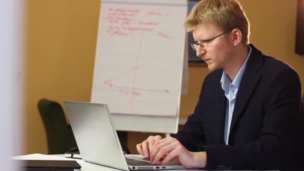 Trabajando hombre de negocios rubio en gafas — Vídeos de Stock