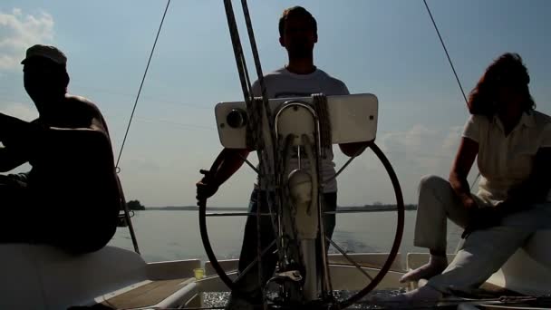 Силуэты людей на лодке — стоковое видео