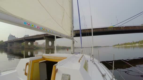 Yacht sailing under city bridge — Stock Video
