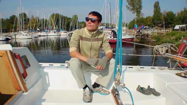 Muž v brýlích, sedí na jachtě — Stock video