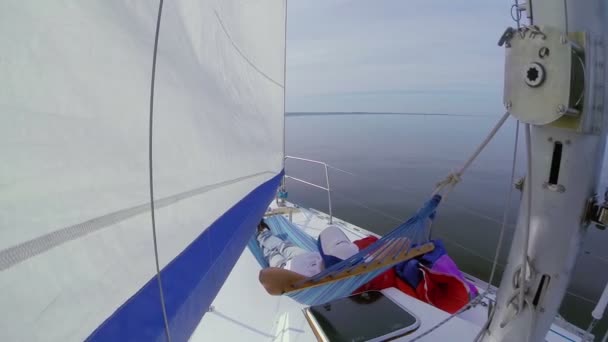 Uomo sdraiato in amaca sulla barca a vela — Video Stock