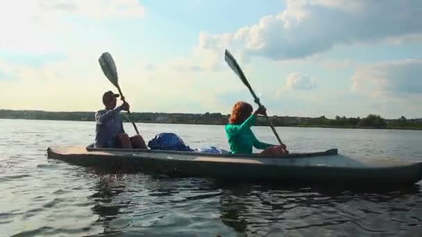 Man och kvinna paddel båt — Stockvideo