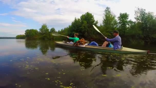 Man en vrouw peddelen boot — Stockvideo