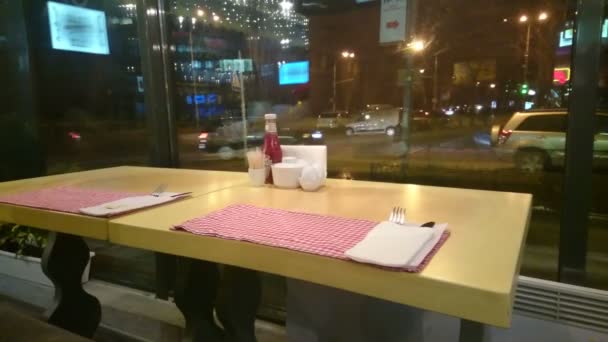 Empty table at restaurant, loneliness, city traffic outside — Stock Video