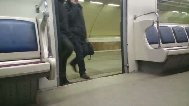 U-Bahn-Türen öffnen sich am Bahnhof, Passagiere steigen ein, nehmen Platz — Stockvideo