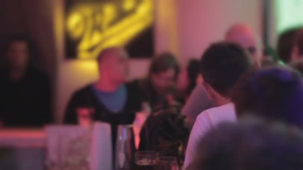 Beaucoup de gens bavardent au bar, barman servant des boissons à la boîte de nuit — Video