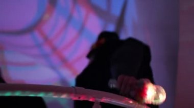 Kadın gece kulübüne giriyor, insanlar üst katta, alt katta yürüyor.