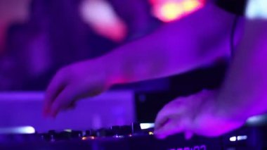 Male hands turning controls, sound equipment, public having fun