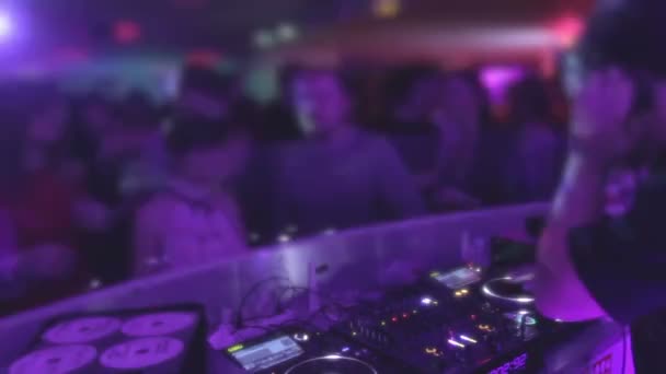 Deejay entreteniendo al público, tocando música, ambiente de discoteca — Vídeos de Stock