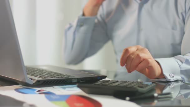 Verkaufsleiter ruft Kunden an, berechnet, fügt Daten auf Laptop ein — Stockvideo