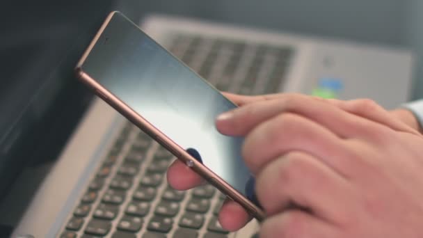 Парень набирает текст сообщения на смартфоне, пальцы касаются экрана — стоковое видео