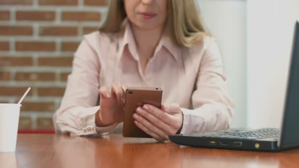 Jovencita navegando por internet, leyendo noticias en smartphone en cafetería — Vídeo de stock