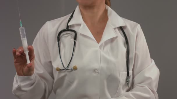 Kobieta lekarz w biały płaszcz trzymając strzykawkę, gotowy do wstrzykiwań — Wideo stockowe