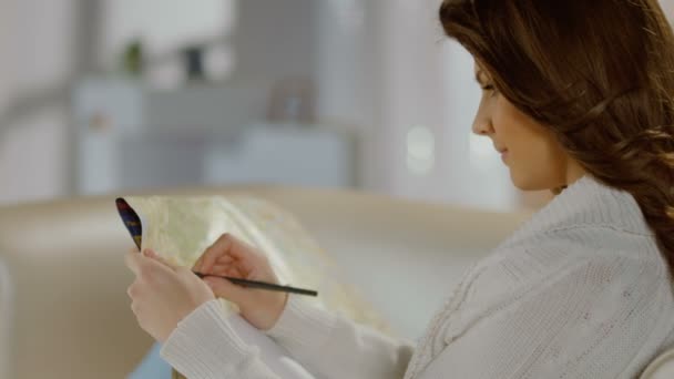 Hermosa joven examinando mapa, tomando notas con lápiz — Vídeo de stock