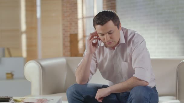 Молодой человек разговаривает по телефону с деловым партнером, заканчивает разговор — стоковое видео