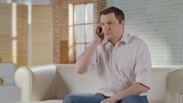 Junger Mann bespricht Geschäftsprobleme in Telefonat zu Hause — Stockvideo
