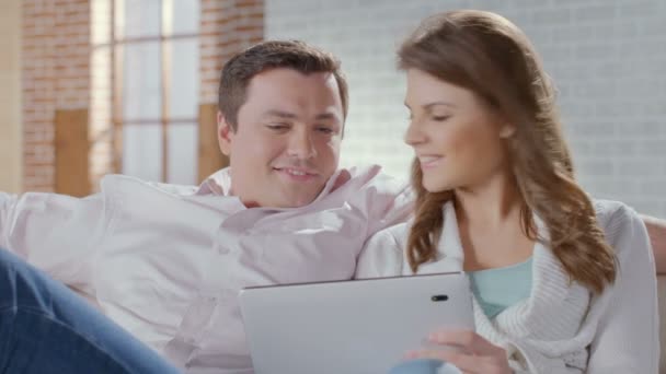 Casal feliz sentado no sofá com tablet pc. Compras online — Vídeo de Stock