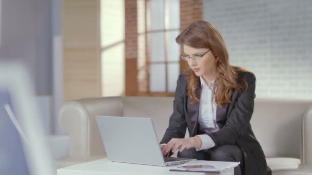 Mulher bonita funcionário do escritório digitando no laptop, sorrindo para a cam — Vídeo de Stock