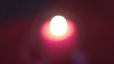 Bulanık kırmızı mum yakma, koyu arka plan, romantizm sembolü