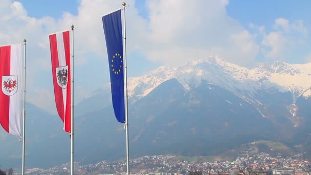 Flaggen mit EU, Österreich, Tiroler Embleme wehen in der Luft, Berge — Stockvideo