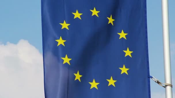 Bandera de la Unión Europea ondeando con viento, fondo azul del cielo — Vídeo de stock