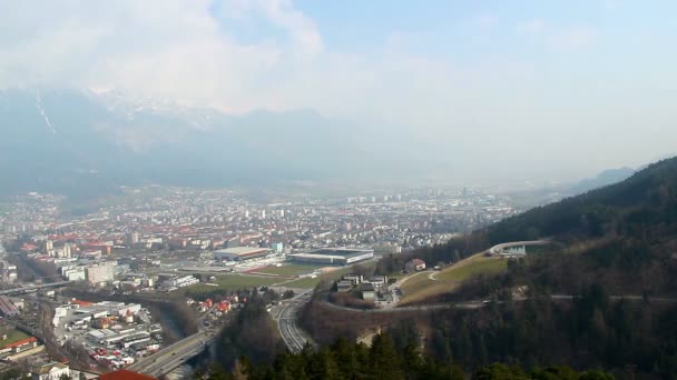 Zajęty ruch na drogach austriackiego miasta na dnie górskim — Wideo stockowe