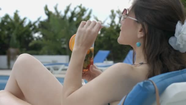 Jovem mulher relaxada bebendo coquetel na praia, desfrutando de descanso — Vídeo de Stock