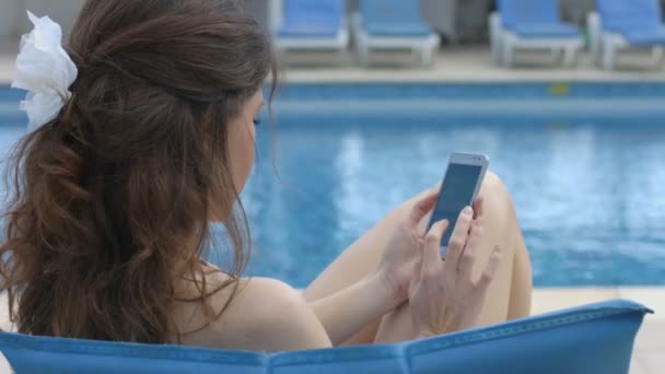Молодая красивая женщина пишет смс на смартфоне, летние каникулы — стоковое видео