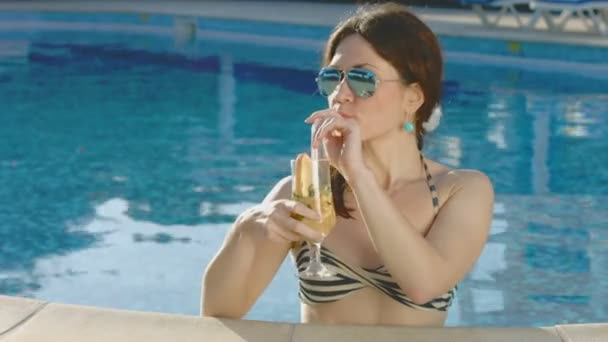 Attraktive Frau entspannt im Pool, trinkt Cocktail im Urlaub — Stockvideo