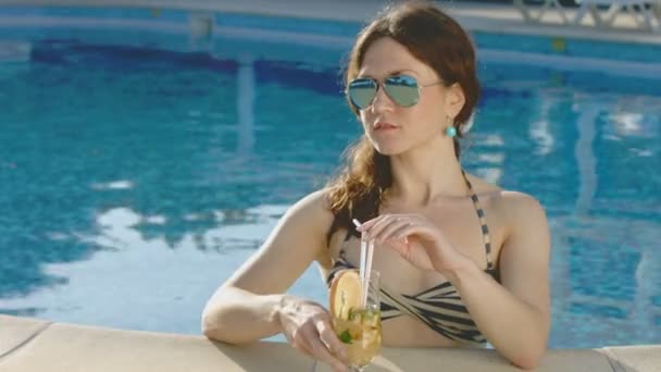 Jonge vrouw lange drankje in zwembad, ontspanning — Stockvideo