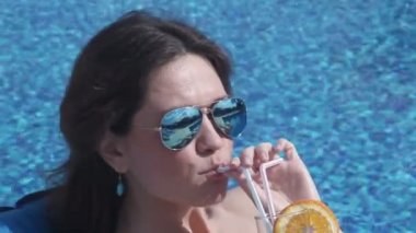 Lüks tatil beldesinde ferahlatıcı kokteyl içen memnun kadın