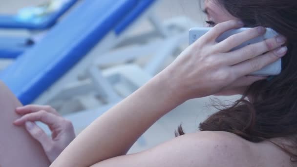 Junge brünette Frau spricht auf dem Smartphone und unterhält sich — Stockvideo
