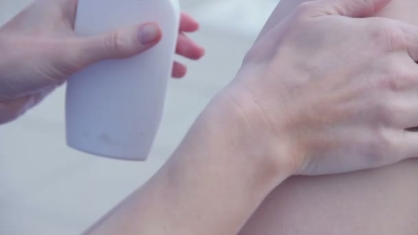 Extrema close up mãos femininas aplicando protetor solar, esfregando pernas — Vídeo de Stock