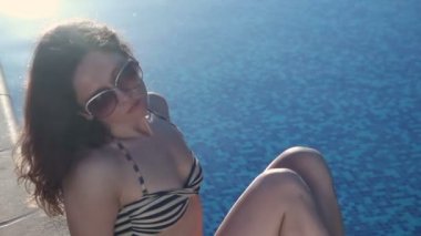 Üzgün yalnız kadın yüzme havuzu, güneşli yaz plajı tarafından oturan