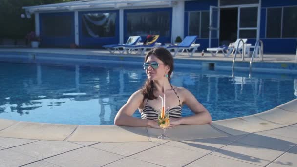 Gelukkige vrouw genieten van verse cocktail in water op luxe strand — Stockvideo