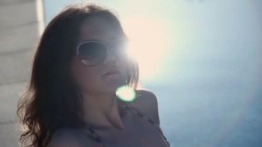 Beautiful woman enjoying sunlight on beach, smiling at camera