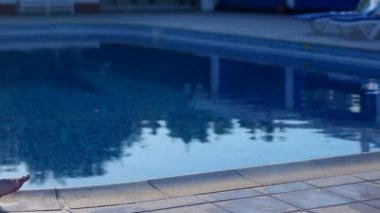 Kristal berraklığında su ile havuz yakınında rahatlatıcı güzel kadın