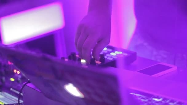Macho DJ mano girando controles en la cubierta de sonido, tocando bandas sonoras — Vídeo de stock