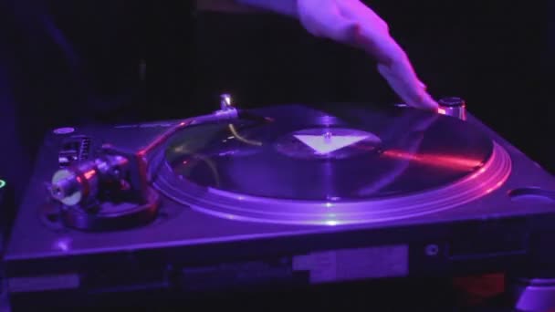 Gros plan d'un DJ masculin qui gratte à la main un disque vinyle sur le pont son — Video
