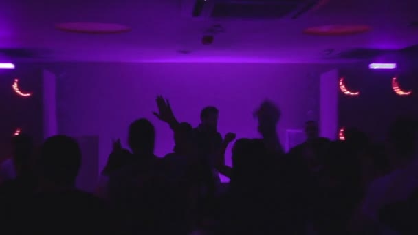 Silhuetas escuras de DJ masculino, muitas pessoas saindo na festa — Vídeo de Stock