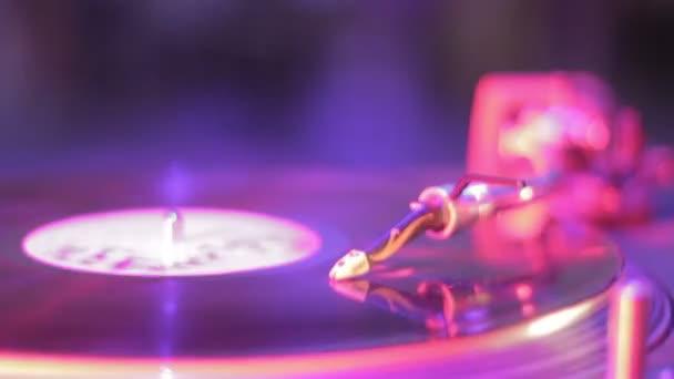 Vinyl record rotating on sound deck, light flashing in nightclub — Stock Video
