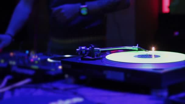 Música tocando en el tocadiscos, DJ masculino trabajando en el club, bailando — Vídeo de stock