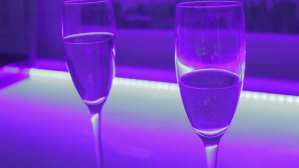 Close-up of two glasses of sparkling champagne, romantic date — Stockvideo